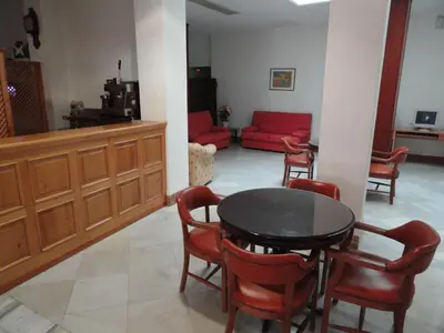 a living room with a table and chairs and a couch at Hotel El Coloso in Jerez de la Frontera