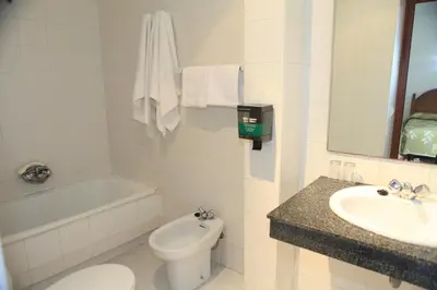 a bathroom with a toilet and a sink and a tub at Hotel El Coloso in Jerez de la Frontera