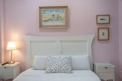 a bedroom with a white bed and a painting on the wall at Casa Patio del Panadero in Cádiz