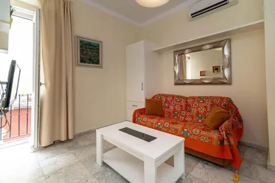 a living room with a red couch and a mirror at Casa Patio del Panadero in Cádiz