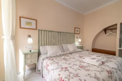 a bedroom with a large bed with a floral bedspread at Casa Patio del Panadero in Cádiz