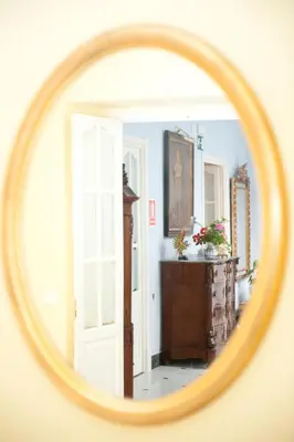 a mirror reflecting a room with a dresser and a door at Casa Patio del Panadero in Cádiz