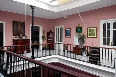a large room with pink walls and a balcony at Casa Patio del Panadero in Cádiz