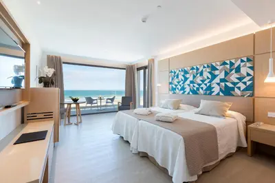 a dining room with a table and chairs and the beach at Hipotels Barrosa Park in Chiclana de la Frontera