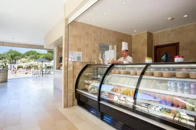 a chef standing behind a counter in a bakery at Hipotels Barrosa Garden in Chiclana de la Frontera