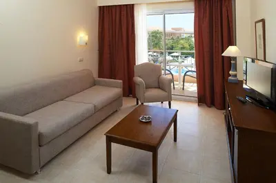 a living room with a couch and a table at Hipotels Barrosa Garden in Chiclana de la Frontera