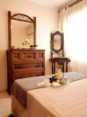 a bedroom with a bed with a dresser and a mirror at Playa de la Calzada in Sanlúcar de Barrameda
