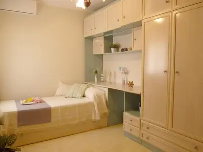 a small bedroom with a bed and a desk at Playa de la Calzada in Sanlúcar de Barrameda
