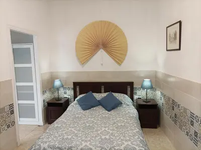 a bedroom with a bed with blue pillows and two lamps at Casa Valientes A - Parking privado gratis & patio interior in Jerez de la Frontera