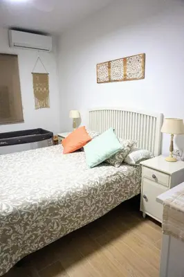 a bedroom with a bed with colorful pillows on it at Villa Horacia in Sanlúcar de Barrameda