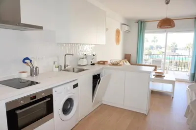 a white kitchen with a sink and a dishwasher at Villa Horacia in Sanlúcar de Barrameda