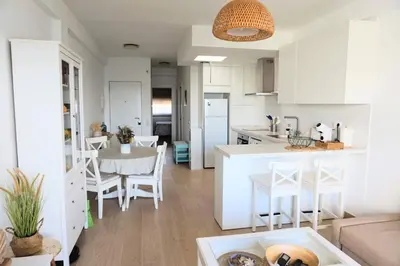 a kitchen and living room with a table and chairs at Villa Horacia in Sanlúcar de Barrameda