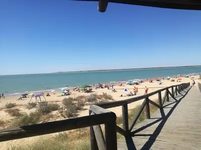 a boardwalk leading to a beach with people on it at Villa Horacia in Sanlúcar de Barrameda