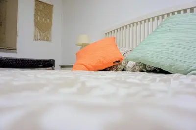 an orange pillow sitting on top of a bed at Villa Horacia in Sanlúcar de Barrameda