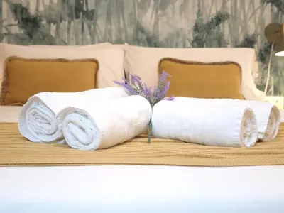 two rolled towels sitting on top of a bed at Apartamento del Mercado Little Apartments in Cádiz