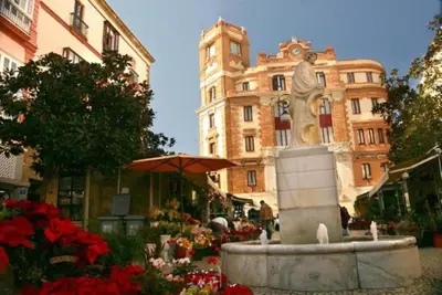 a fountain in front of a building with a clock tower at Apartamento del Mercado Little Apartments in Cádiz