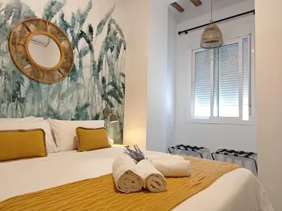 a bedroom with a large bed with towels on it at Apartamento del Mercado Little Apartments in Cádiz