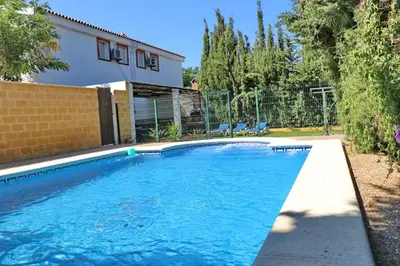 a swimming pool in front of a house at Chalet Pradillo in Conil de la Frontera