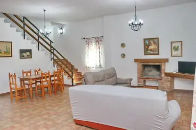a living room with a couch and a dining room at Chalet Pradillo in Conil de la Frontera