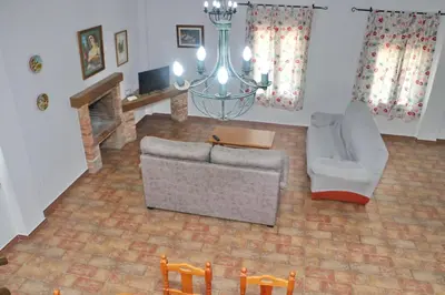 a living room with a couch and a chandelier at Chalet Pradillo in Conil de la Frontera