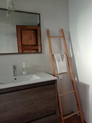 a bathroom with a sink and a ladder next to a mirror at El Vivero in Chiclana de la Frontera