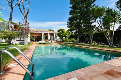 a swimming pool in the backyard of a house at Villa Cai in Chiclana de la Frontera