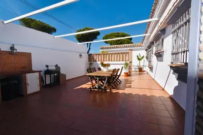 a patio with a table and chairs on a house at Villa Cai in Chiclana de la Frontera