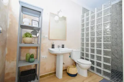 a bathroom with a sink and a toilet and a mirror at Villa Cai in Chiclana de la Frontera