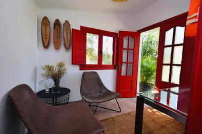 a room with red doors and a table and chairs at Villa Cai in Chiclana de la Frontera