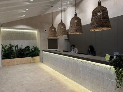 a lobby with people sitting at a bar with pendant lights at Hostal del Faro in Conil de la Frontera