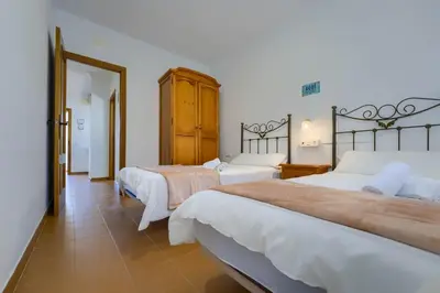 a hotel room with two beds and a doorway at Hostal del Faro in Conil de la Frontera