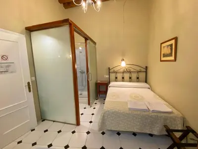 a bedroom with a bed and a glass door at Pensión España in Cádiz