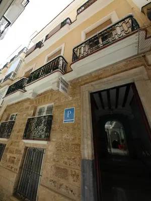 a building with a parking sign in front of a door at Pensión España in Cádiz