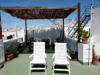 a group of white chairs sitting on a roof at Pensión España in Cádiz