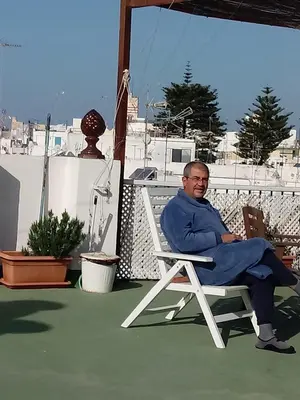a man sitting in a chair on a patio at Pensión España in Cádiz