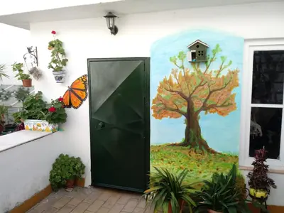 a door with a painting of a tree and a bird house at Pensión España in Cádiz