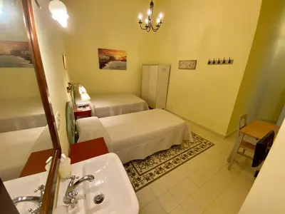 a hotel room with two beds and a sink at Pensión España in Cádiz