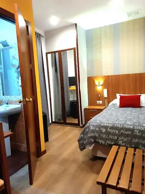 a bedroom with a bed and a bathroom with a sink at Hostal San Francisco in Cádiz