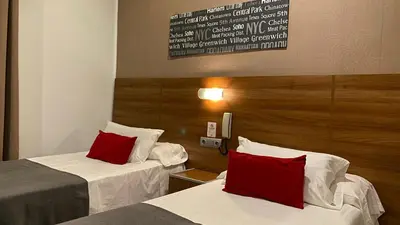 a hotel room with two beds with red pillows at Hostal San Francisco in Cádiz