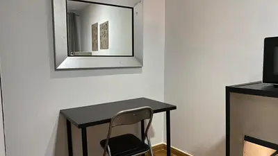 a table with a chair and a mirror on a wall at Hostal San Francisco in Cádiz
