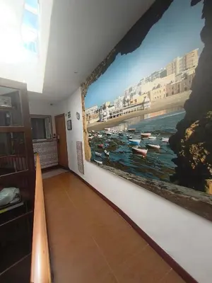 a room with a large painting of boats on the wall at Hostal San Francisco in Cádiz