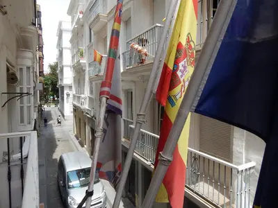 a row of flags on the side of a building at Hostal Canalejas in Cádiz