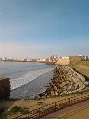 a beach with a bunch of rocks in the water at Hostal Canalejas in Cádiz