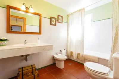 a bathroom with a sink and a toilet and a mirror at Bonito Chalet Con Vistas in Sanlúcar de Barrameda