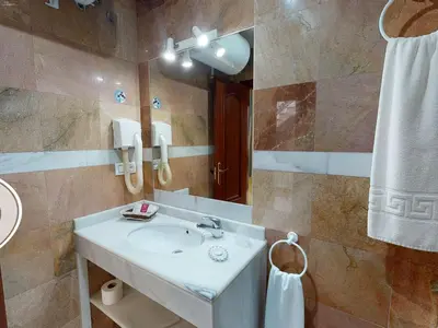 a bathroom with a sink and a mirror at Hotel La Parrita in Rota