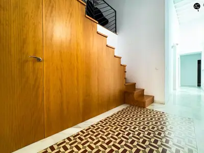 a hallway with a staircase with a wooden door and a rug at Casa Columela Cádiz Grupo AC Gestión in Cádiz