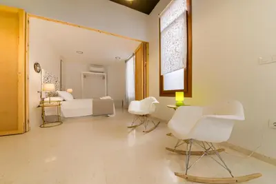 a bedroom with a bed and two white chairs at Casa en Plaza de la Merced_Centro Flamenco_Cádiz in Cádiz