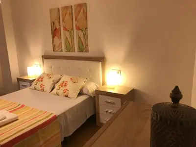 a bedroom with a bed and two lamps on tables at Piso Aurora in Sanlúcar de Barrameda