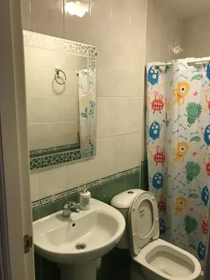 a bathroom with a sink and a toilet and a mirror at Piso Aurora in Sanlúcar de Barrameda