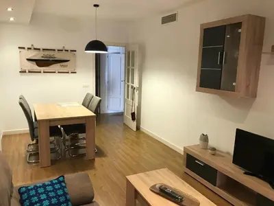 a living room with a table and a tv at Piso Aurora in Sanlúcar de Barrameda
